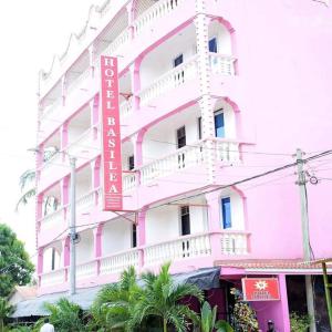 un edificio rosa con un cartello davanti di Hotel Basilea Mtwapa a Mtwapa