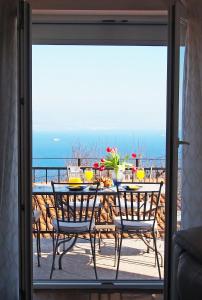 uma mesa e cadeiras numa varanda com vista para o oceano em Apartman Mimi em Lovran