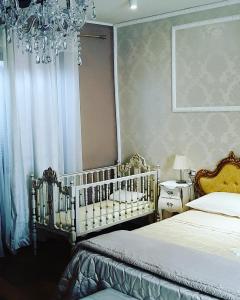 sypialnia z 2 łóżkami i żyrandolem w obiekcie Antica Norma Alloggio Turistico w mieście Norma