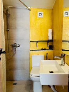 La salle de bains est pourvue de toilettes blanches et d'un lavabo. dans l'établissement Traditional Detached Corfu House, 50m to village square, à Liapades
