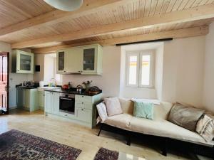 ein Wohnzimmer mit einem Sofa und einer Küche in der Unterkunft Traditional Detached Corfu House, 50m to village square in Liapades