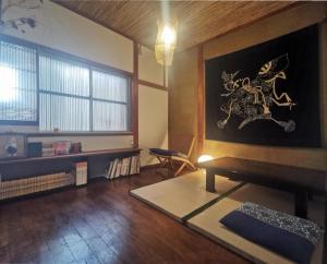 a living room with a table and a painting on the wall at 心遊亭ー和風の間 Shin Yu Tei in Kanazawa