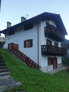 un edificio blanco con balcones en un lateral en Appartamenti Nonno Gianni en Rocca Pietore