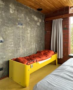 a yellow bed in a room with a wall at rodune in Koksijde