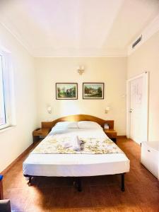 a bedroom with a large bed and two pictures on the wall at Hotel Resi in Rome