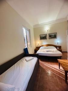 una camera d'albergo con due letti e un tavolo di Hotel Resi a Roma
