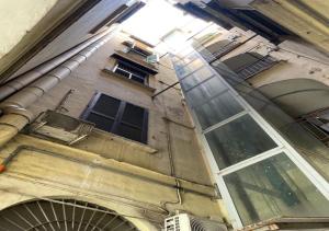 un vecchio edificio con finestre sul lato di La casa di nonna Maria a Napoli