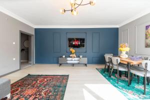 un soggiorno con pareti blu e tavolo e sedie di Hexa Suites Hotel a Istanbul