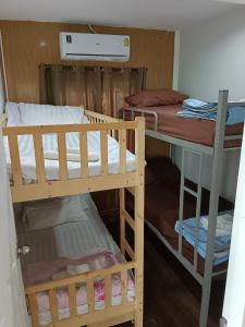 a room with two bunk beds and a table at Bangkok Pool Villa Suvarnabhumi in Ban Hua Takhe