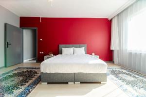 een slaapkamer met een rode muur en een bed bij Hexa Suites Hotel in Istanbul