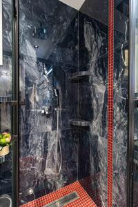 a bathroom with a shower with black marble at Sergio Luxury Appartment in Nea Potidaea