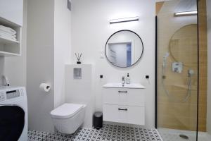 a bathroom with a toilet and a sink and a mirror at Apartamenty Międzywodzie Plażowa Park in Międzywodzie