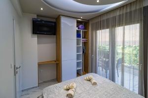 a room with a bed and a tv and a window at Sergio Luxury Appartment in Nea Potidaea