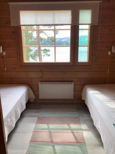 two beds in a room with two windows at Katriina, huom! sijaitsee saaressa, locates on island in Tahkovuori