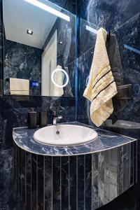 La salle de bains est pourvue d'un lavabo et d'un miroir. dans l'établissement Sergio Luxury Appartment, à Potidée
