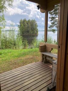 a porch of a house with a bench and a view of the water at Katriina, huom! sijaitsee saaressa, locates on island in Tahkovuori