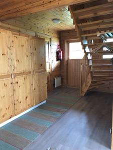 Großes Zimmer mit Holzwänden und einer Treppe in einer Hütte in der Unterkunft Katriina, huom! sijaitsee saaressa, locates on island in Tahkovuori