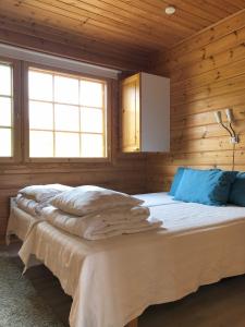 ein Schlafzimmer mit einem Bett in einer Holzhütte in der Unterkunft Katriina, huom! sijaitsee saaressa, locates on island in Tahkovuori