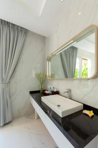 スミニャックにあるBajra Bali Villa Seminyakのバスルーム(洗面台、鏡付)