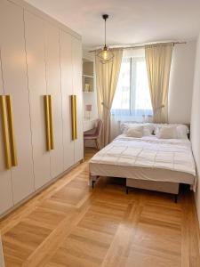 a bedroom with a large bed and a window at Apartman Goldea in Lukavica +12 photos