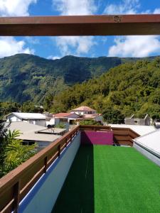 a view from the balcony of a house with a green lawn at Chez Claudia in Salazie