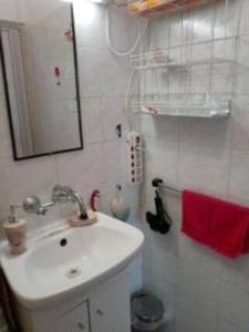 Baño blanco con lavabo y espejo en Minigarden Hause, en Eger