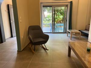a living room with a chair and a table at Spacious and beautiful house in Piraeus