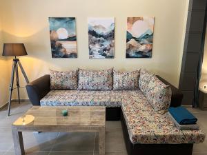 a couch in a living room with paintings on the wall at Spacious and beautiful house in Piraeus