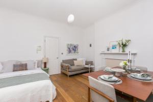 1 dormitorio con cama, mesa y sofá en Light filled studio with view of Regents Park en Londres