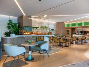 a restaurant with tables and chairs in a cafeteria at EVEN Hotels Shenzhen Guangming Cloud Park, an IHG Hotel in Shenzhen