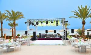 an outdoor wedding ceremony on the beach with palm trees at InterContinental Aqaba by IHG in Aqaba +121 photos