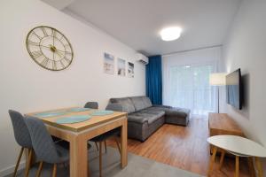 a living room with a table and a couch at Apartamenty Międzywodzie Plażowa Park in Międzywodzie