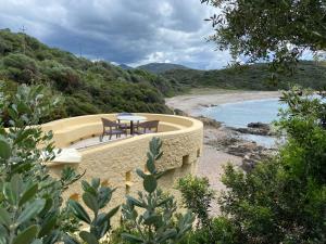 d'une terrasse avec une table et des chaises à côté d'une rivière. dans l'établissement Résidence Les Mandiles, à Cargèse