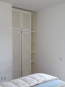 a bedroom with a closet with white shutters at Trilocale in residence Verdesirente in Rocca di Mezzo