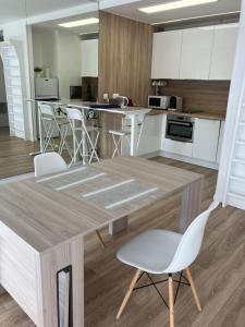 uma cozinha com uma mesa de madeira e cadeiras brancas em Paris 42m Studio plus terrace em Paris