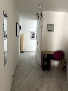 a hallway with a table and a chair in a room at bel appartement climatisé centre in Albi