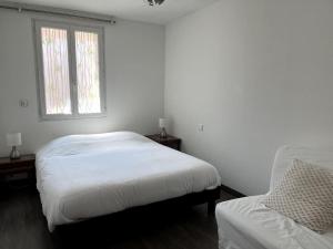 a white bedroom with two beds and a window at bel appartement climatisé centre in Albi