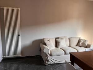 a living room with a white couch and a radiator at Casa Cavour in Montecatini Terme