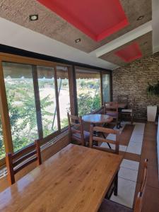 a restaurant with wooden tables and chairs and windows at Guest House KrisHen in Përmet +45 photos