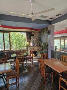 a restaurant with tables and chairs and a fireplace at Guest House KrisHen in Përmet