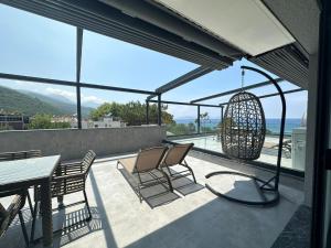 a balcony with a table and chairs and a view of the ocean at Artan Suites Tatil Evleri in Guzelcamlı