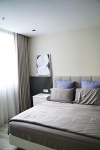 1 dormitorio con 1 cama grande con almohadas azules en Modern & Minimalist 2-Bedroom Apartment in PJ en Petaling Jaya