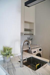 um lavatório de cozinha com uma torneira no balcão em Modern & Minimalist 2-Bedroom Apartment in PJ em Petaling Jaya