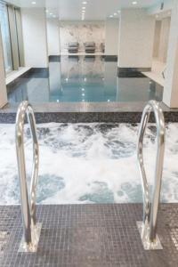 3 bed luxury spacious apartment with pool في مانشستر: تجمع المياه مع وجود صفين معدنيين في المبنى