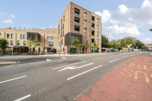 uma rua da cidade vazia com um edifício e uma estrada vazia em Roomspace Serviced Apartments- Buttermere House em Kingston upon Thames