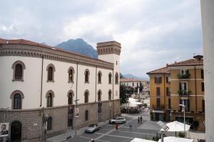 un edificio con una torre de reloj en una ciudad en [Piazza XX settembre] - feel the centre en Lecco