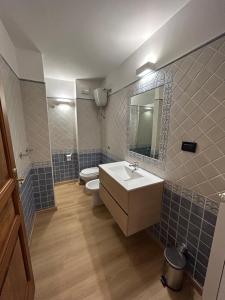 een badkamer met een wastafel, een toilet en een spiegel bij Pietrasuite Santa Brigida in Roccaraso