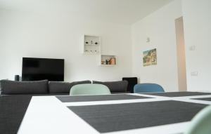een kamer met een tafel en stoelen en een flatscreen-tv bij [Piazza XX settembre] - feel the centre in Lecco