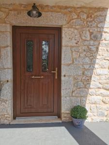 una puerta de madera de una casa de piedra con una planta en Angie's Stone house, en Peletá