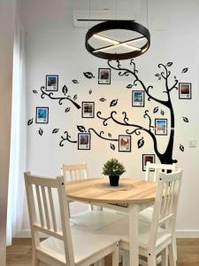 una mesa de comedor con un árbol y cuadros en la pared en Acogedor apartamento 5 personas, en Valencia